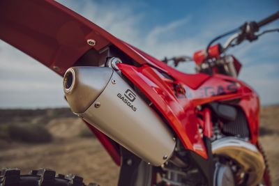 The exhaust of a red offroad motorcycle.