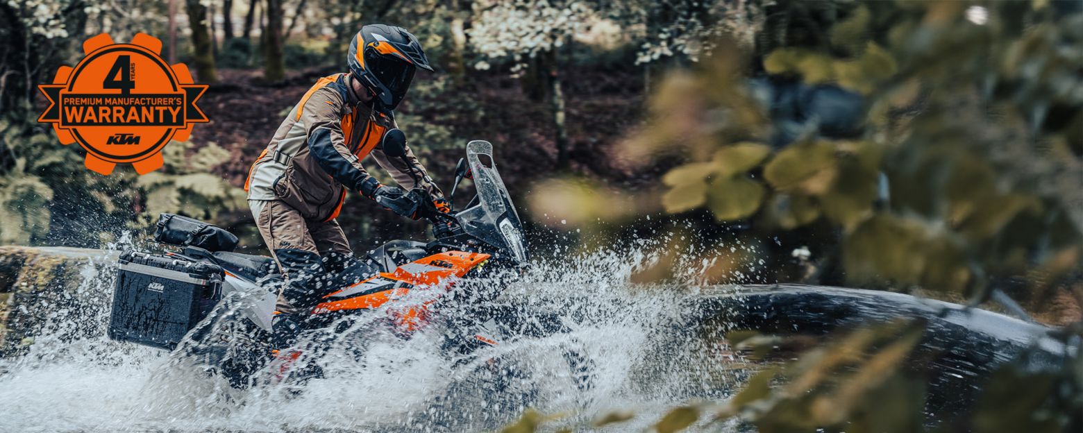 A person rides a KTM Adventure motorcycle along a rugged dirt trail, showcasing adventure and outdoor exploration.