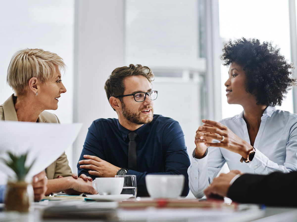 Give us difficult and well show you easy. Shot of a group of businesspeople sitting together in a meeting.