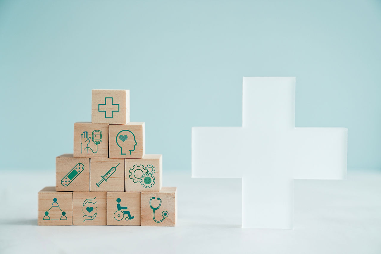 Wooden blocks with health care icons and big cross, healthcare, care plan, wellness center