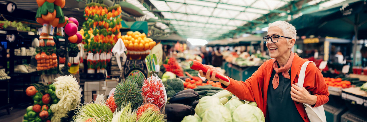 Person choosing fresh fruit and vegetables at an indoor market.