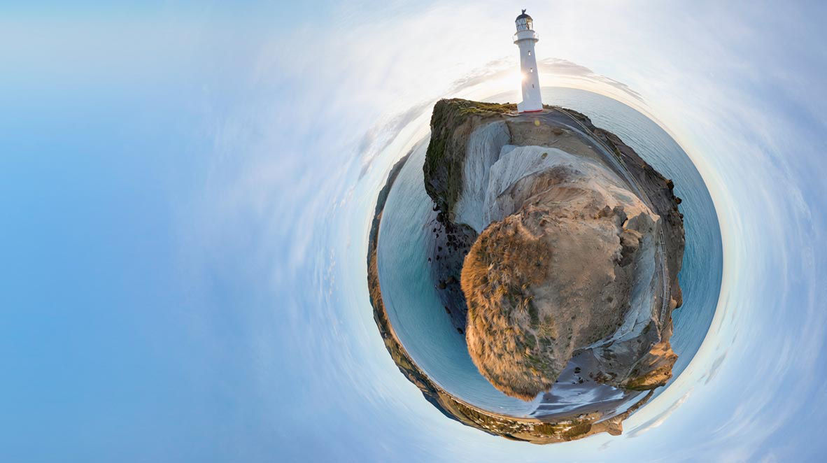 Panoramic spherical view of a lighthouse on a rocky coastal headland.