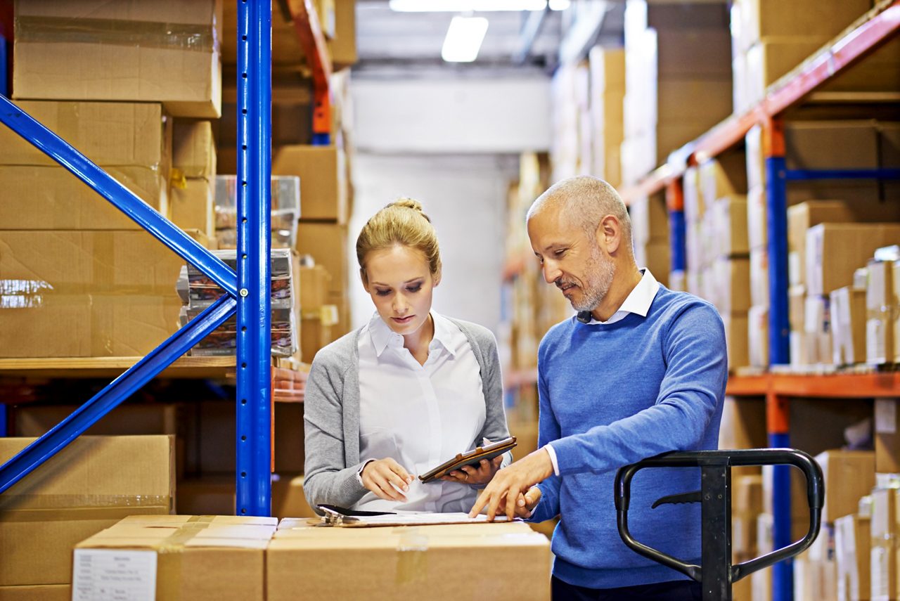 warehouse-personnel-reviewing-inventory-and-logistics-information-among-storage-racks