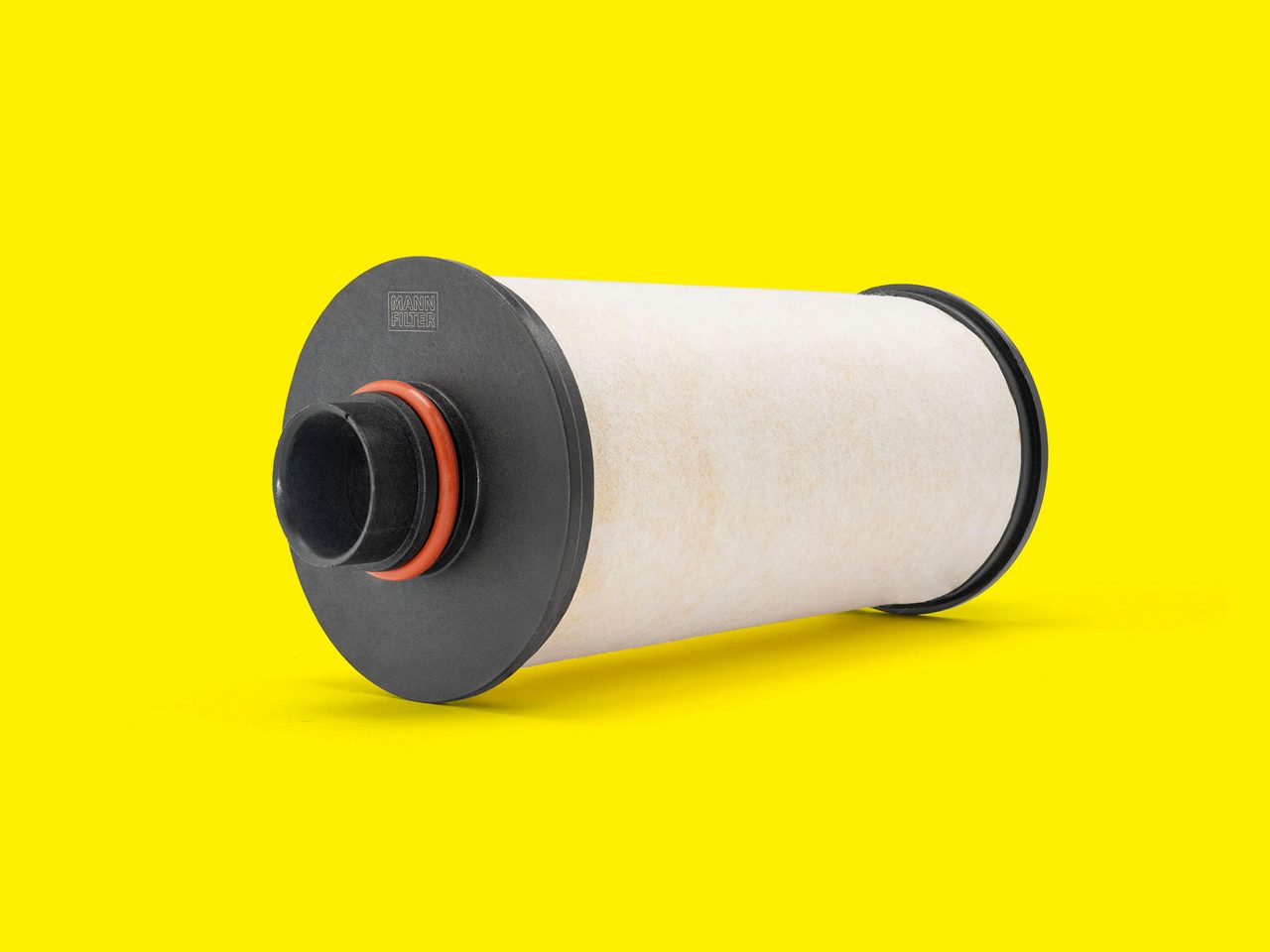 A white MANN-FILTER air oil separator filter with a black base displayed on a yellow background