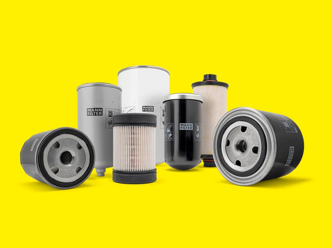 A selection of filters from MANN-FILTER for industrial engines displayed on a yellow background