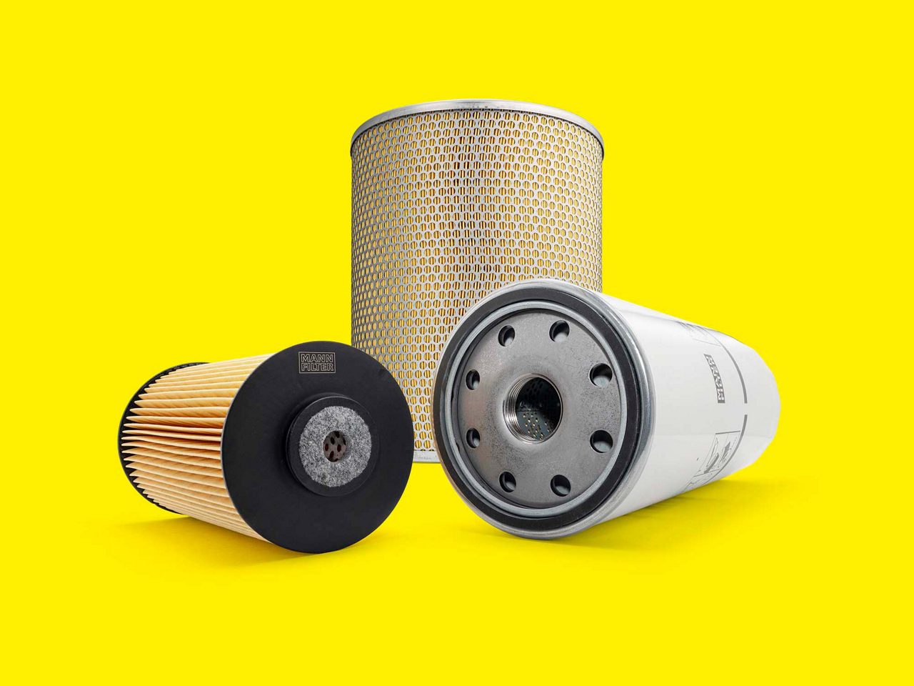 A selection of marine filters, including fuel, oil, and air filters, on a yellow background