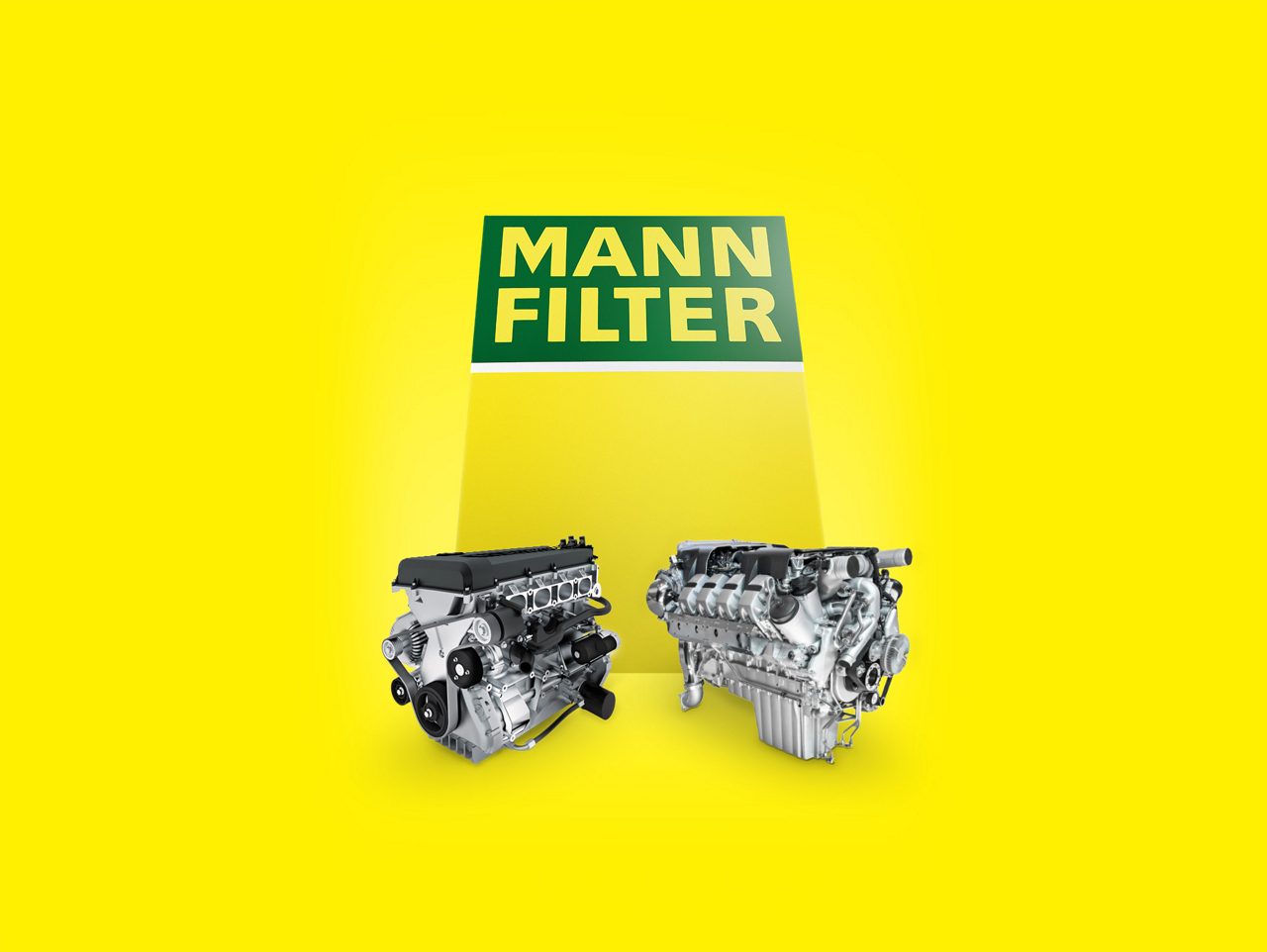 Two industrial engines with MANN-FILTER products in front of a big yellow-green MANN-FILTER box