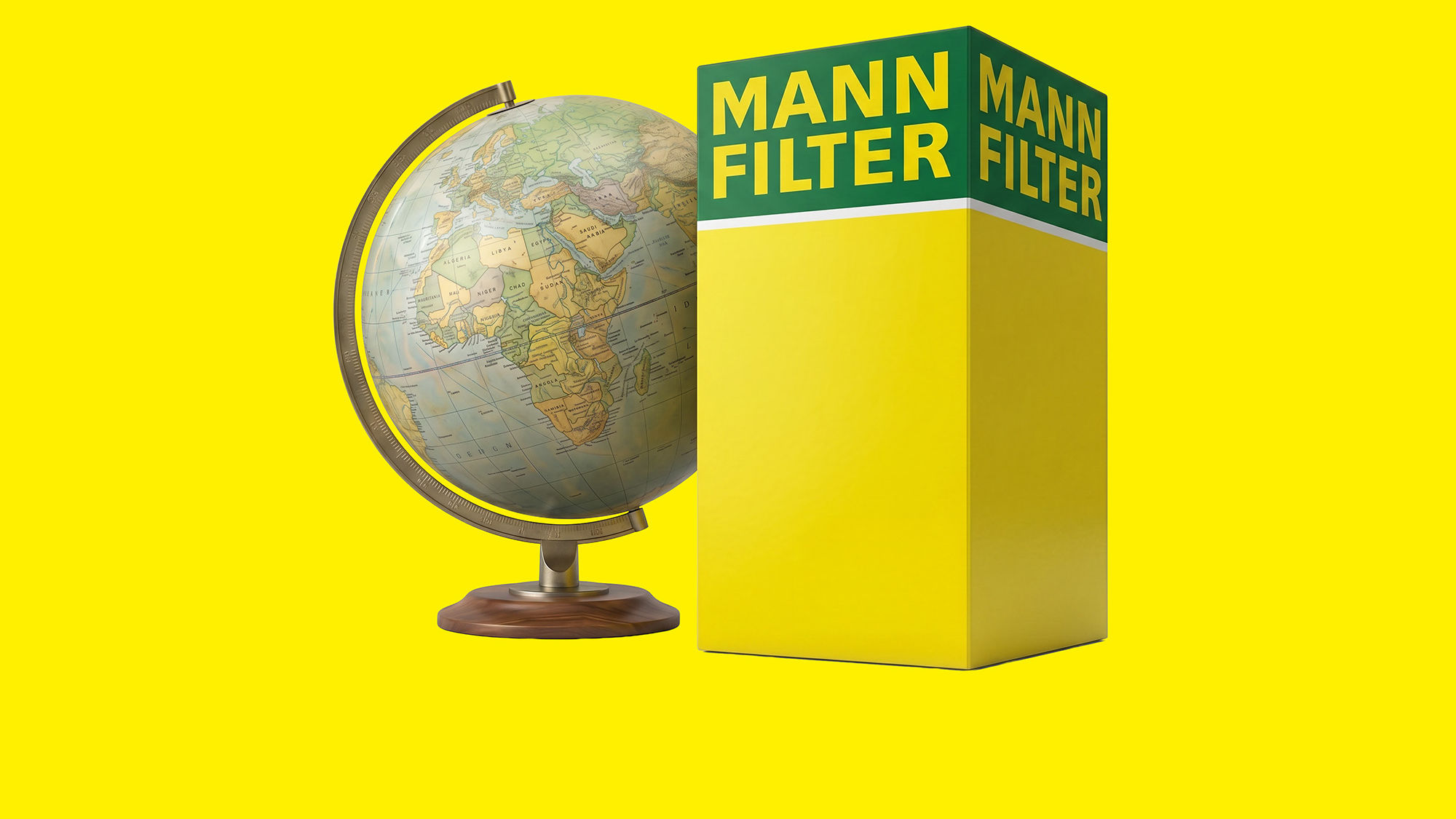 Un globo terráqueo clásico junto a una caja plegable de productos MANN-FILTER en tonos amarillos y verdes