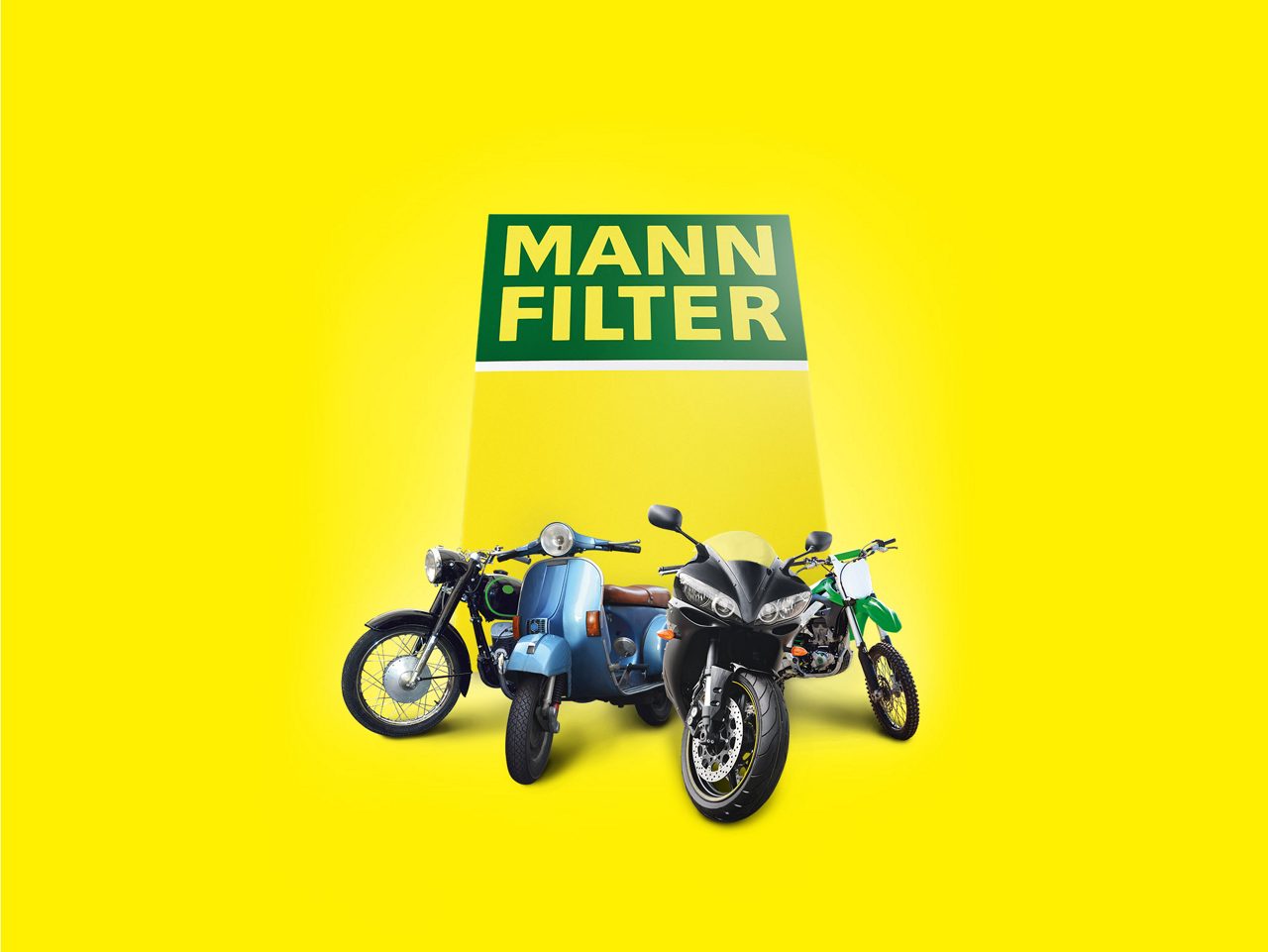 Four motorcycles displayed with a MANN-FILTER product packaging behind them