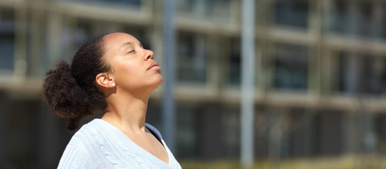 Woman breathing air on the street