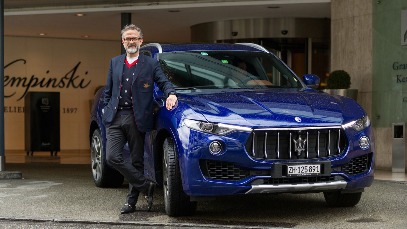 Massimo Bottura que se apoya al Maserati Levante