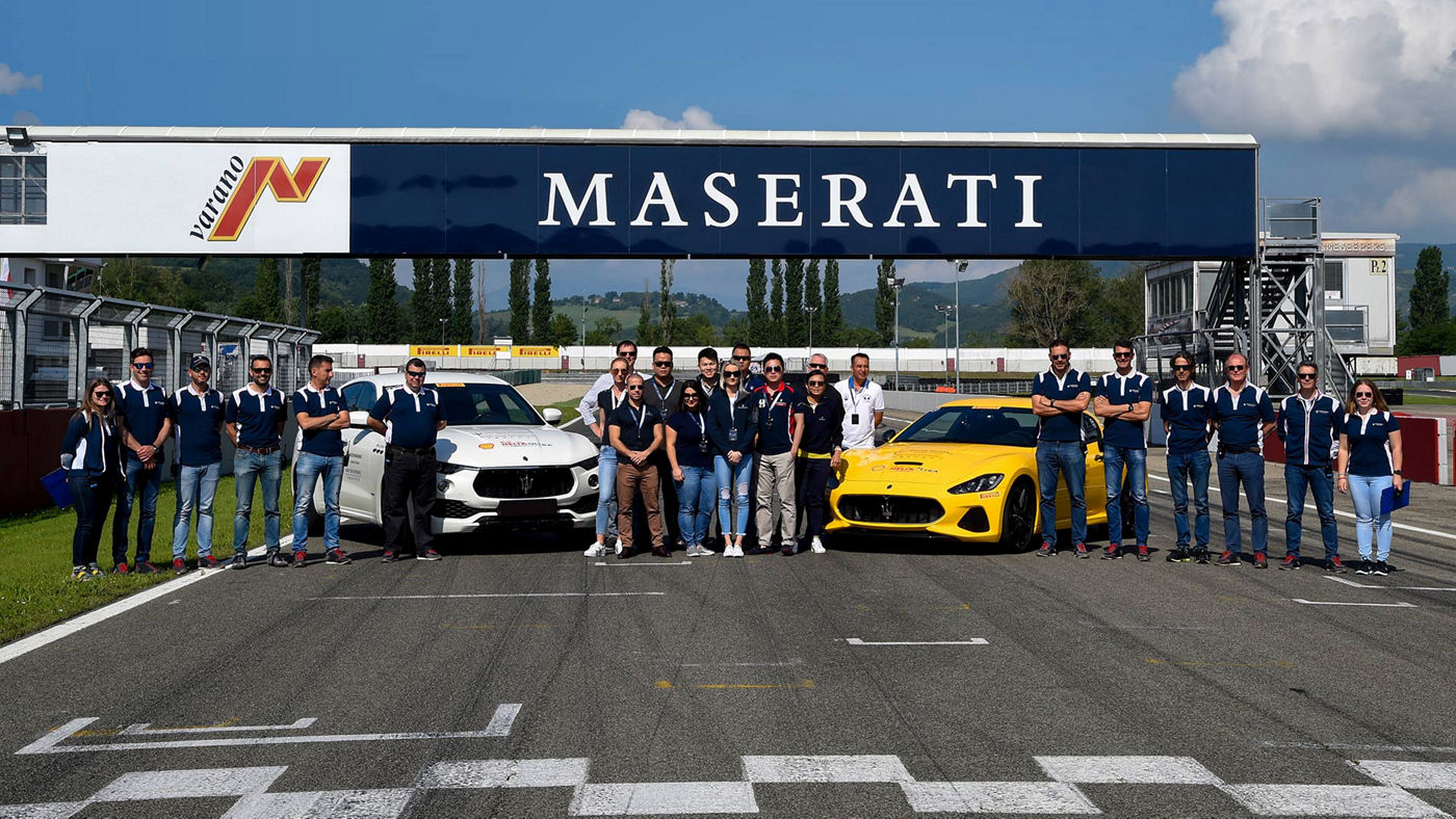 Grupo de personas en la pista de carreras de Maserati