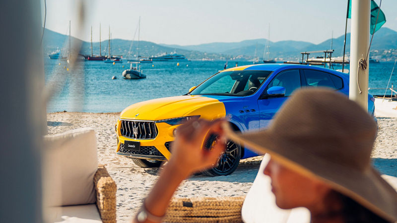 SUV Maserati Levante Hybrid amarillo y azul en la playa de Saint Tropez