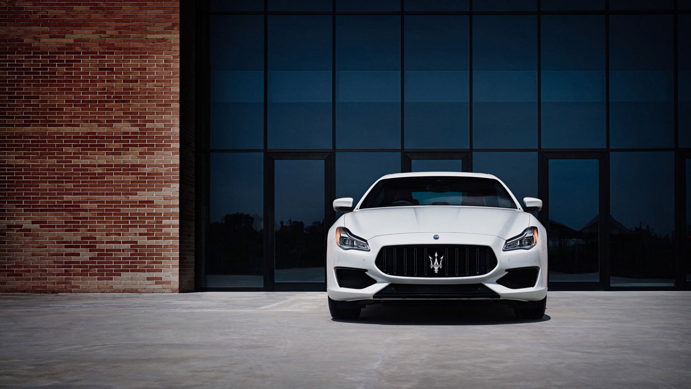 Maserati Quattroporte in Weiß vor einem modernen Haus