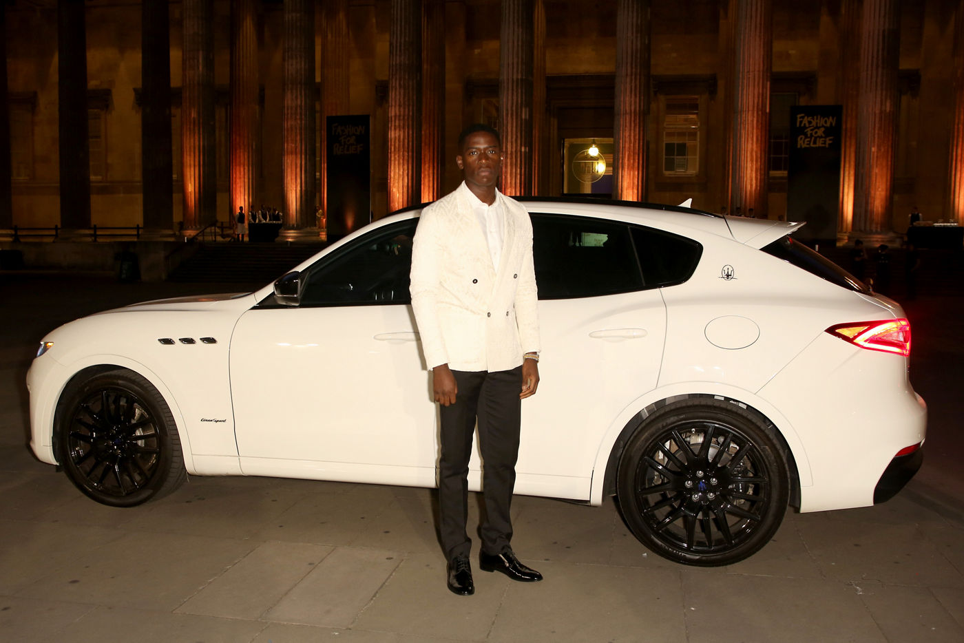 Damson Idris en la Fashion For Relief delante de un Maserati Levante