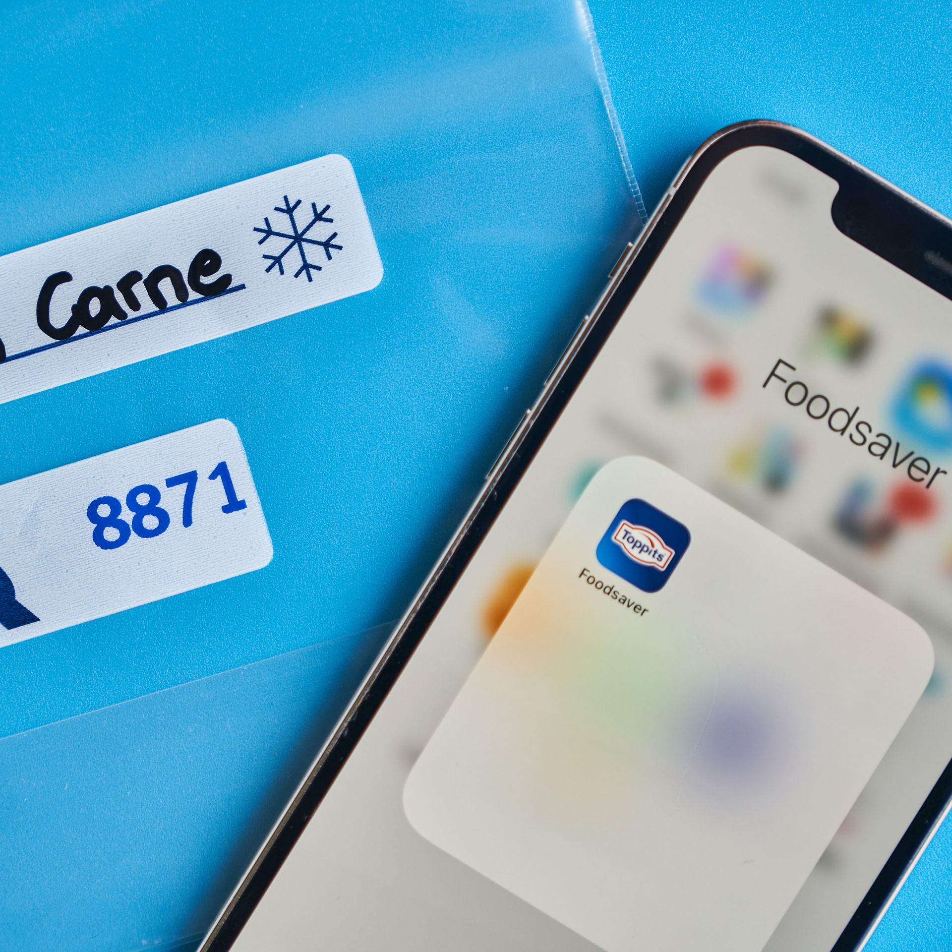 Smartphone auf Gefrierbeutel mit Frischecode auf blauem Hintergrund