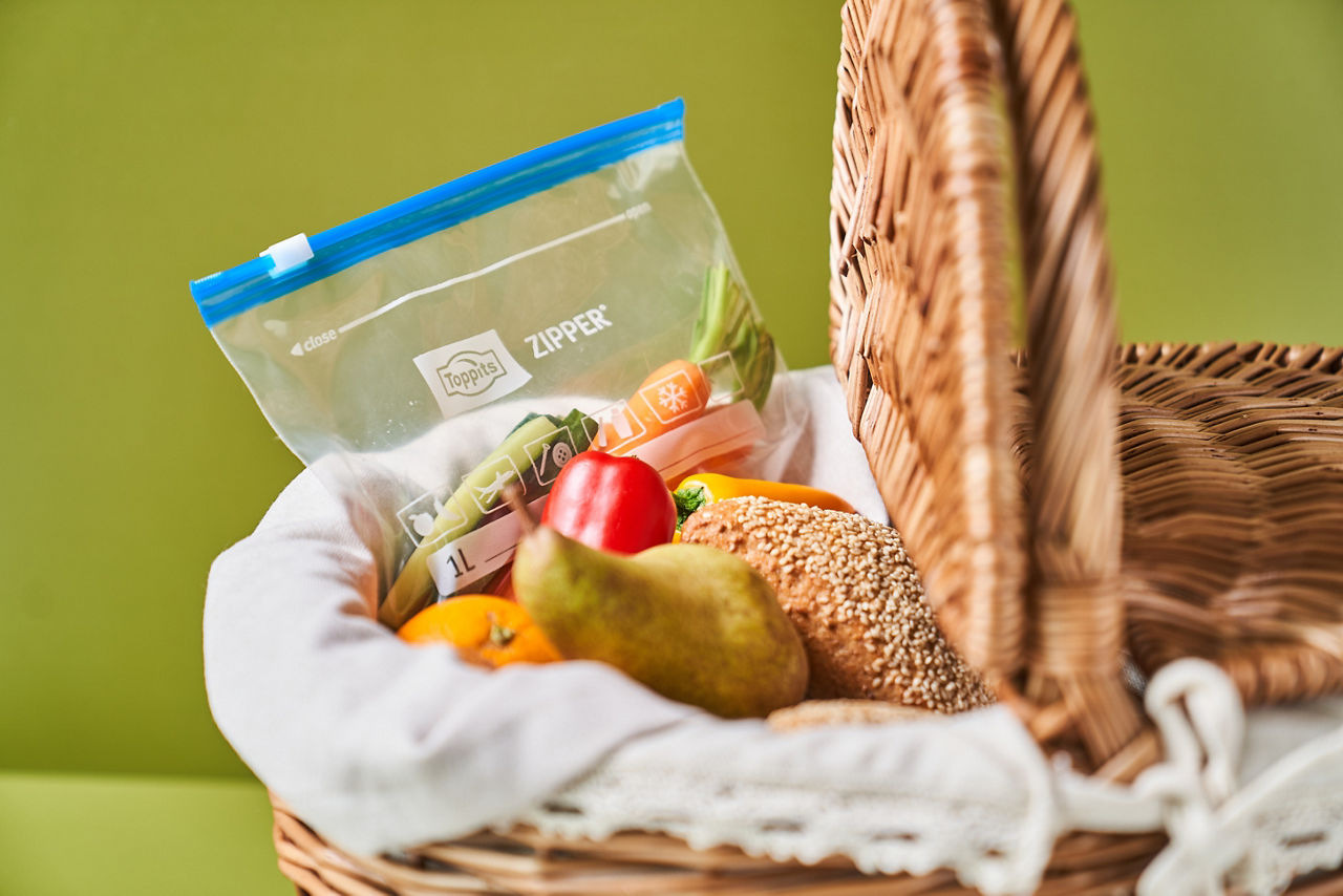 Picknickkorb mit Obst, Brötchen und einem wiederverschließbaren Toppits Zipper Beutel mit Gemüse