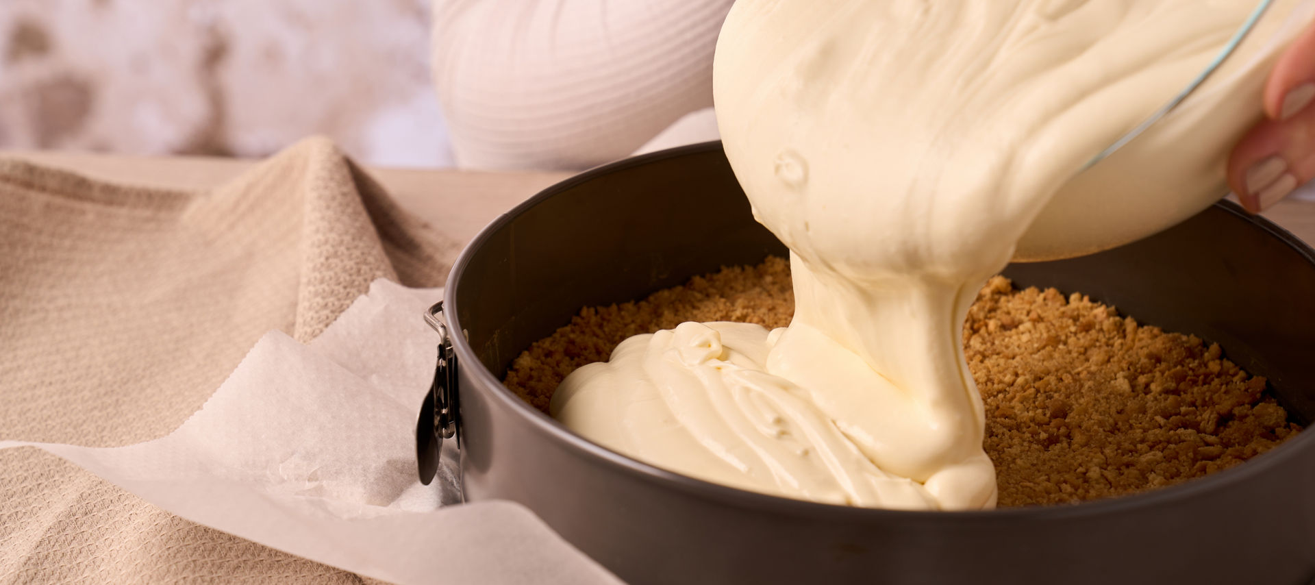 Papier cuisson Toppits dans un moule à charnière, dans lequel on verse une masse crémeuse.