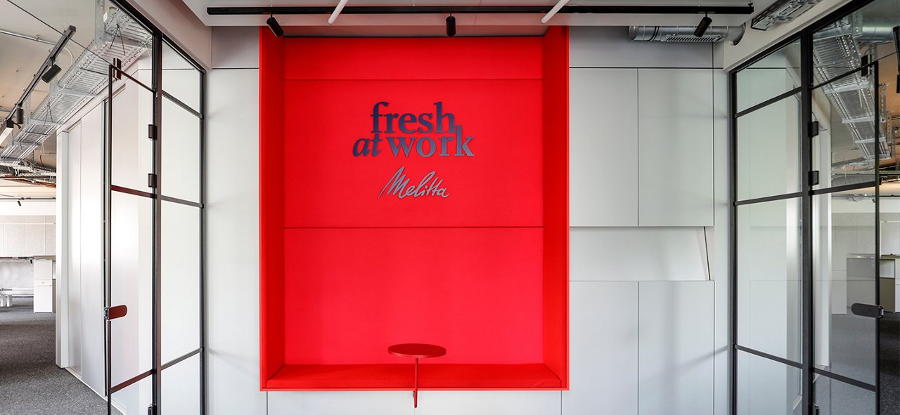 Lagerhalle in den Farben dunkelblau, rosa und rot mit fresh at work Logo und LKW, der Ware annimmt. 