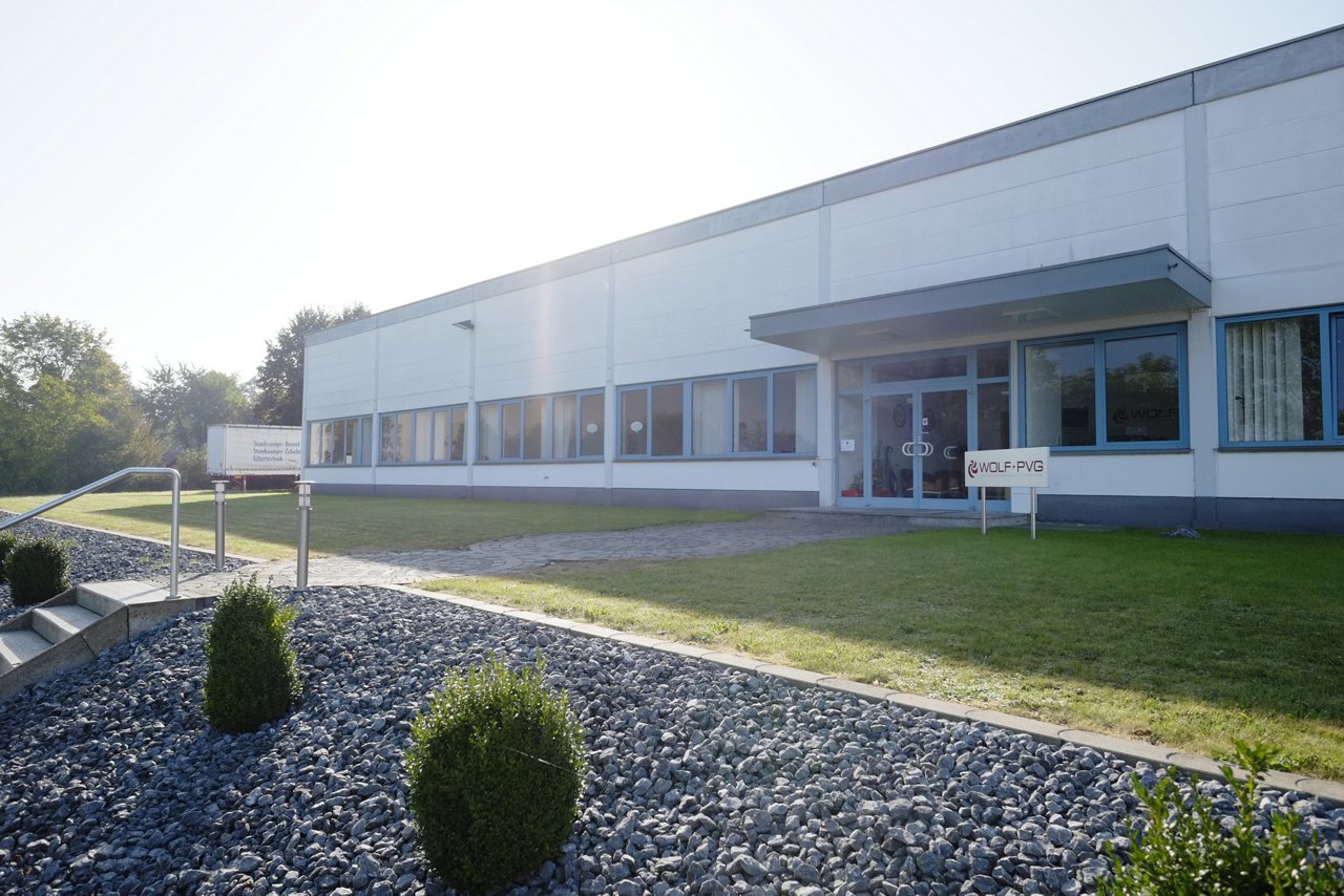 Weißes Bürogebäude mit Flachdach von Wolf PVG im Sonnenschein.