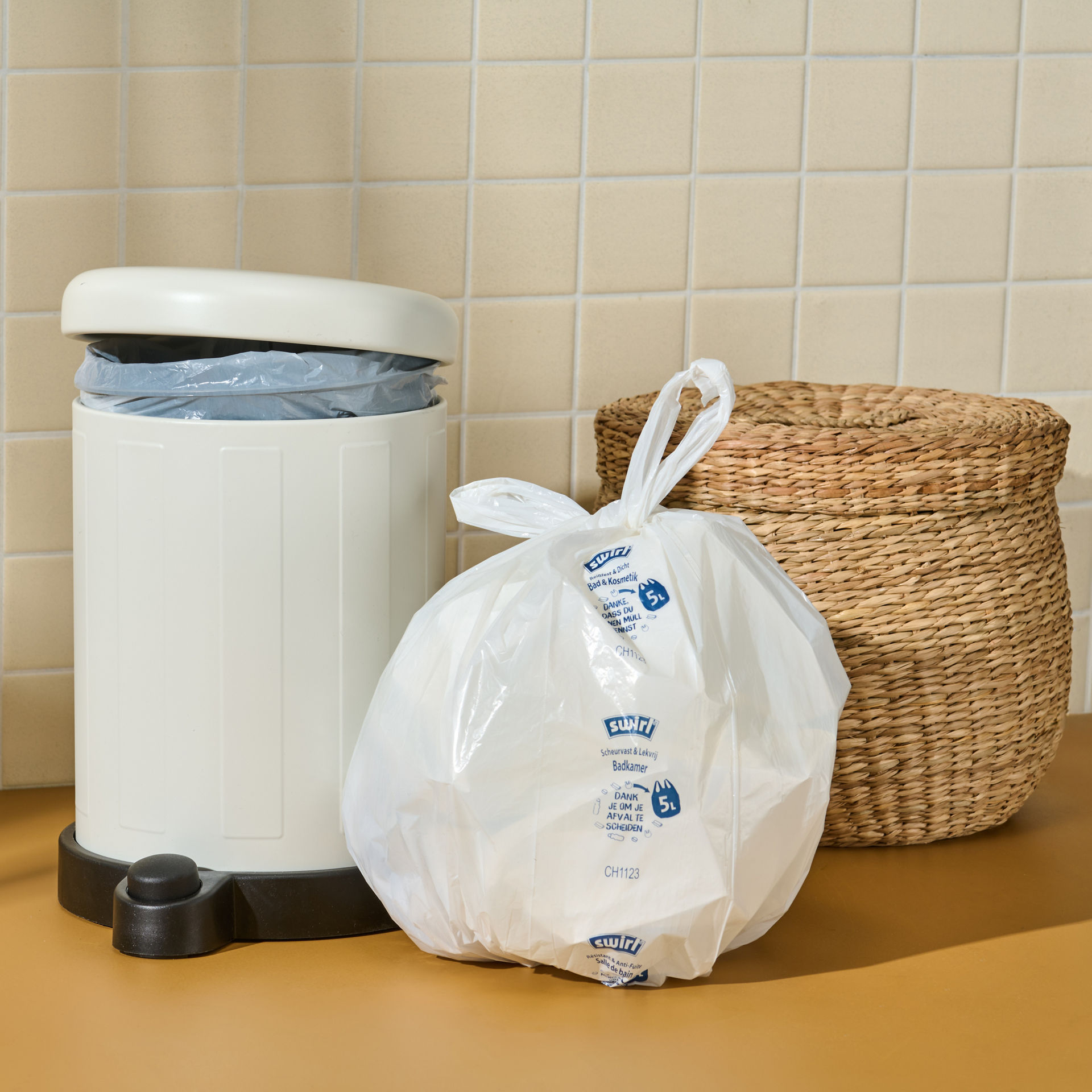 Gefüllter 5L Swirl Bad & Kosmetikbeutel steht vor Mülleimer