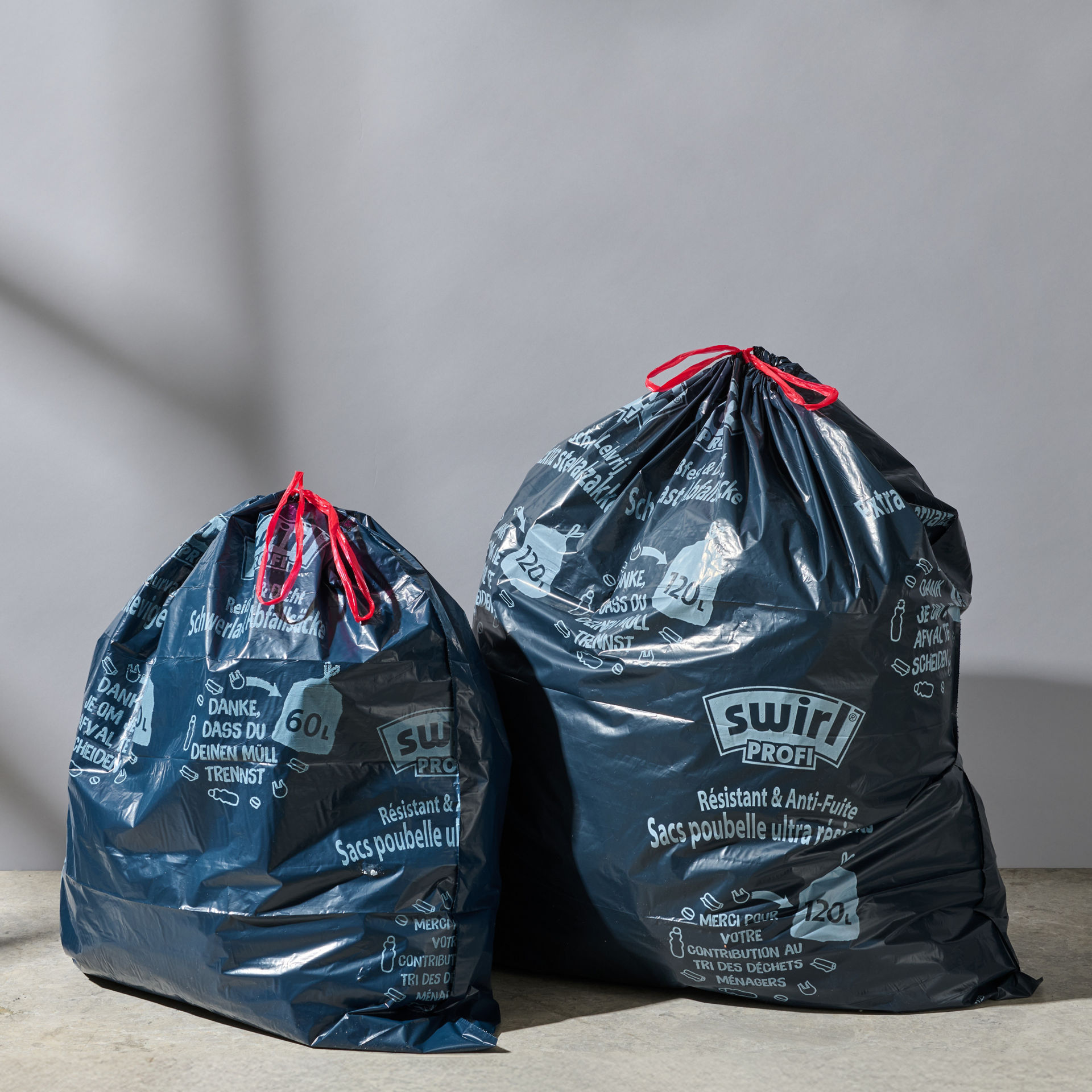Zwei gefüllte Swirl Schwerlastsäcke (60L, 120L) stehen nebeneinander