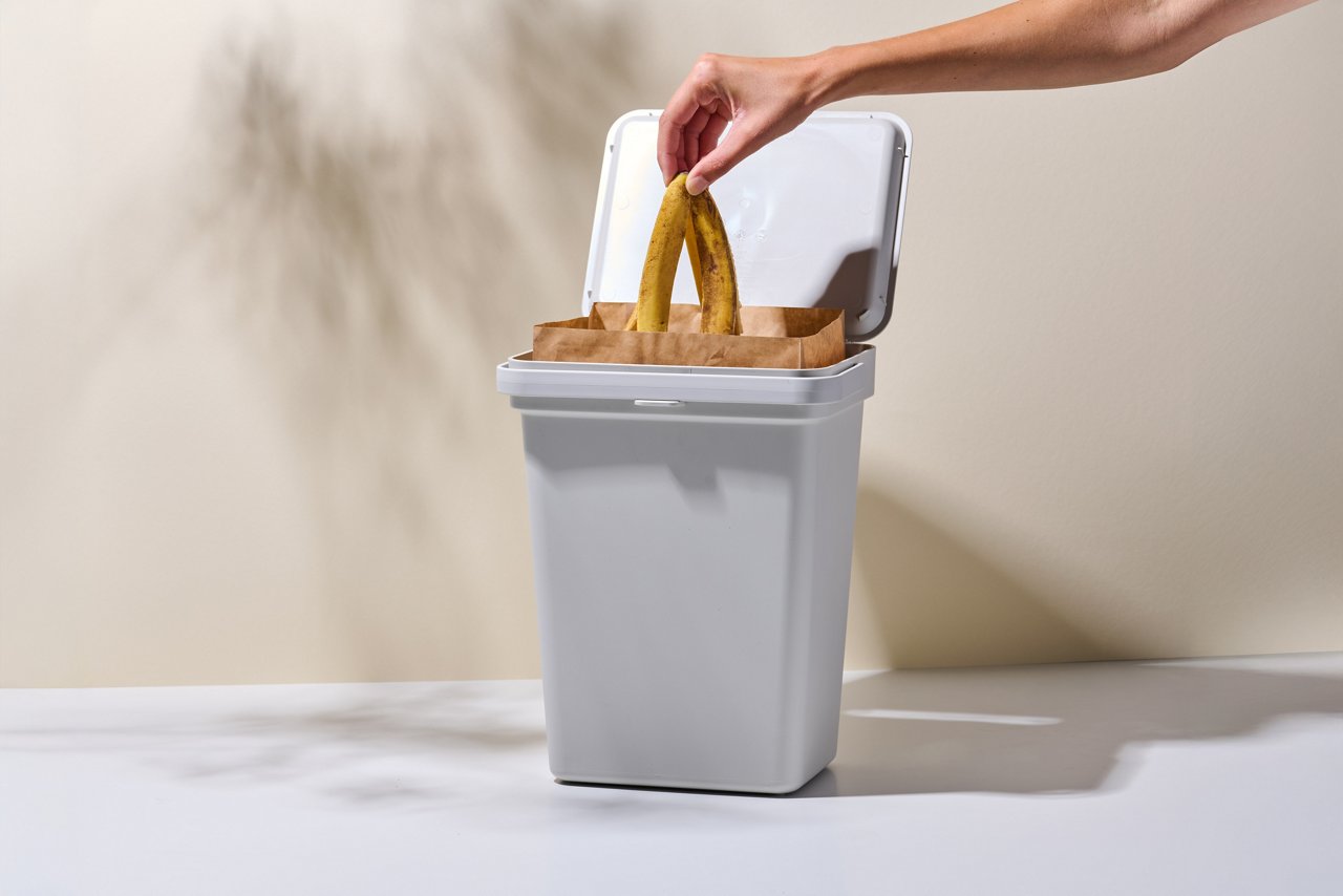 Bananenschale wird im Swirl Bio-Müll Papierbeutel im Mülleimer integriert entsorgt