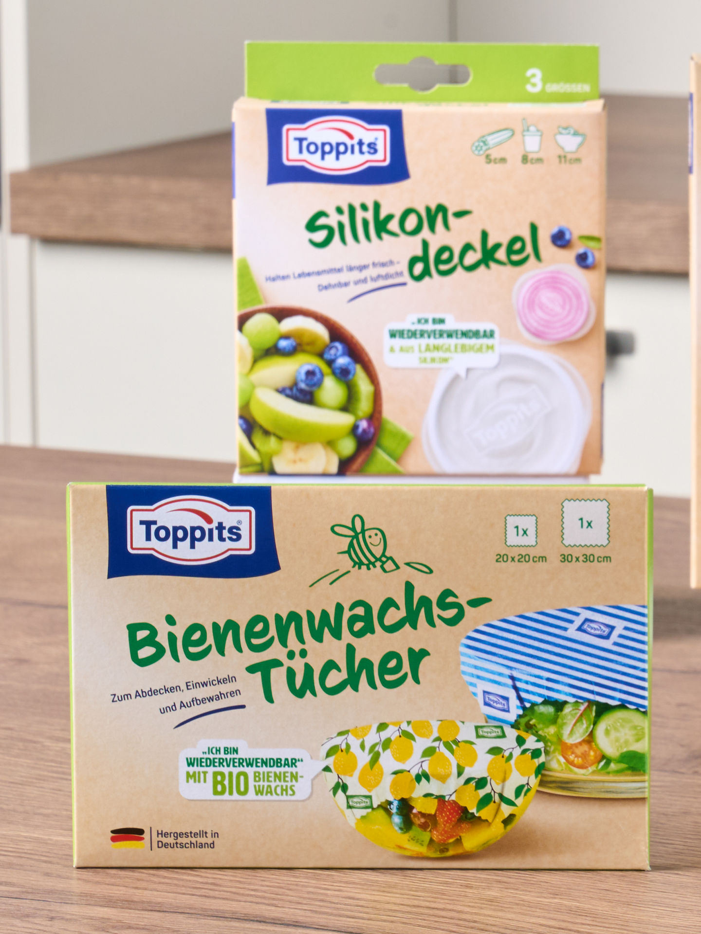 4 Produktverpackungen von wiederverwendbaren Produkten der Marke Toppits stehen neben- bzw hinztereinander auf einer Küchenarbeitsplatte 