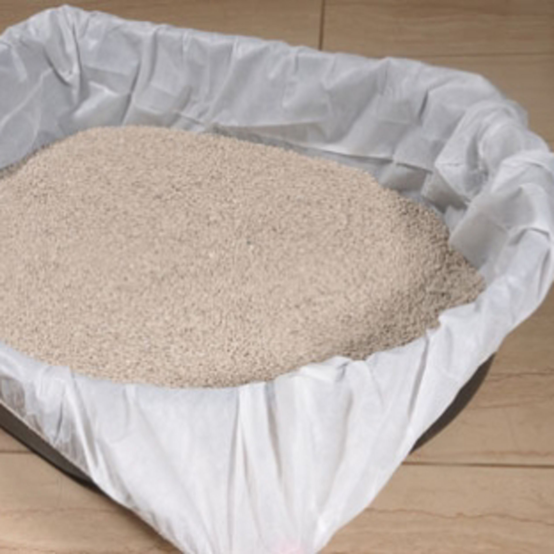 Vue de dessus d’un bac à litière recouvert d’un sac de protection blanc contenant de la litière. 