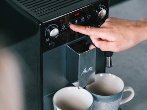 Aromatischer Kaffeegenuss (04).png – Man using touch display, capturing a calm and aromatic coffee experience