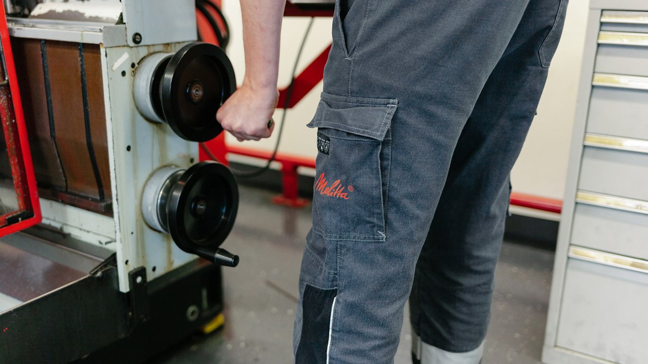 Young, blond-haired man in work clothes tinkering in training workshop