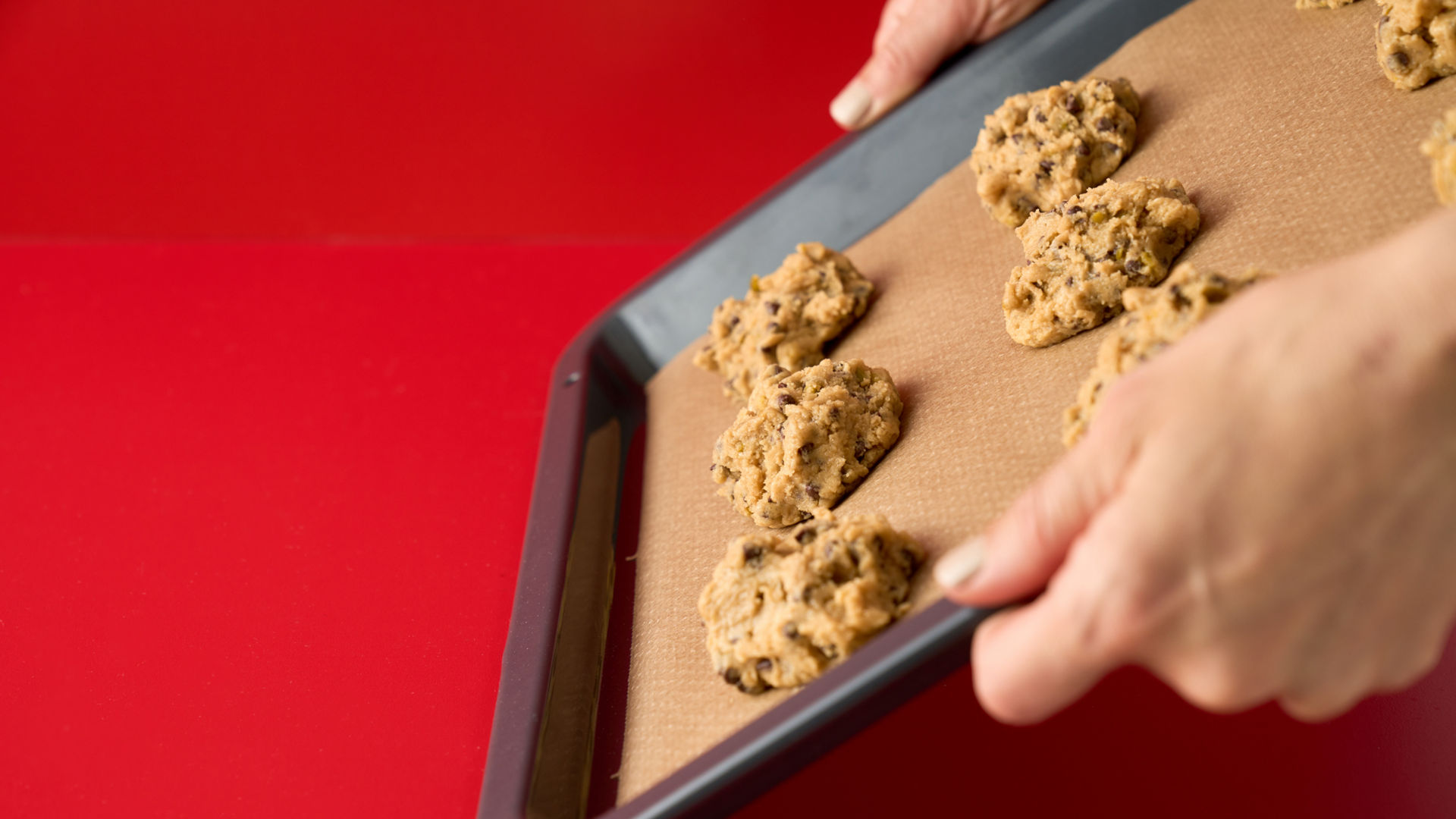 Blech mit Schoko-Cookies wird mit Toppits Backpapier abgelegt.