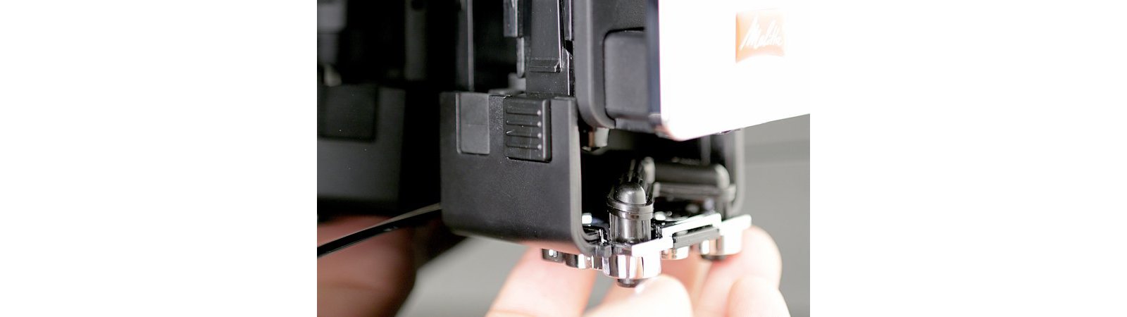 Melitta official close view of a removable Barista TS Smart outlet and milk-system component being handled for cleaning