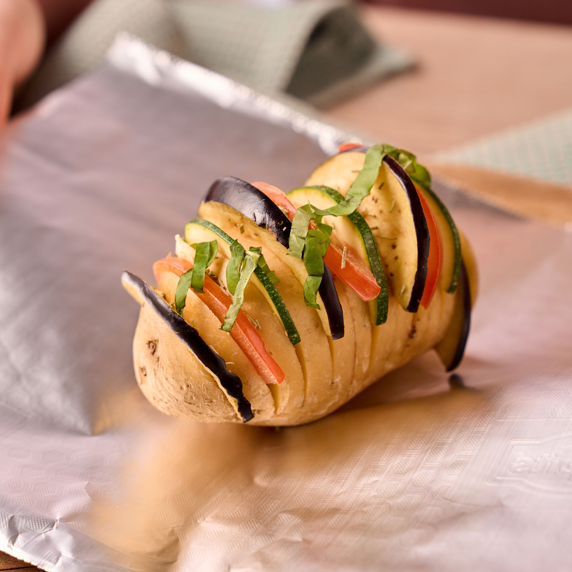 En fyldt kartoffel ligger på aluminiumsfolie