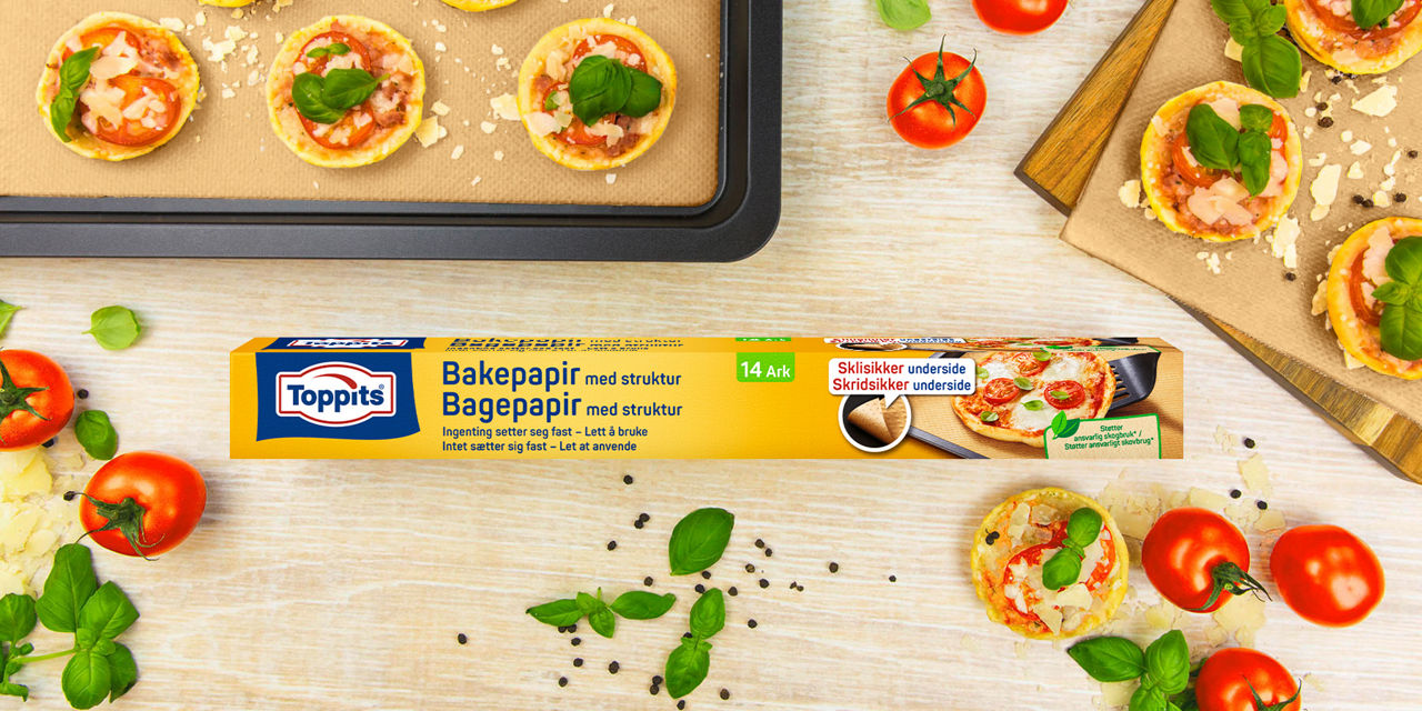Headerbillede med Toppits® bagepapir emballage og fyldt bageplade med friske ingredienser