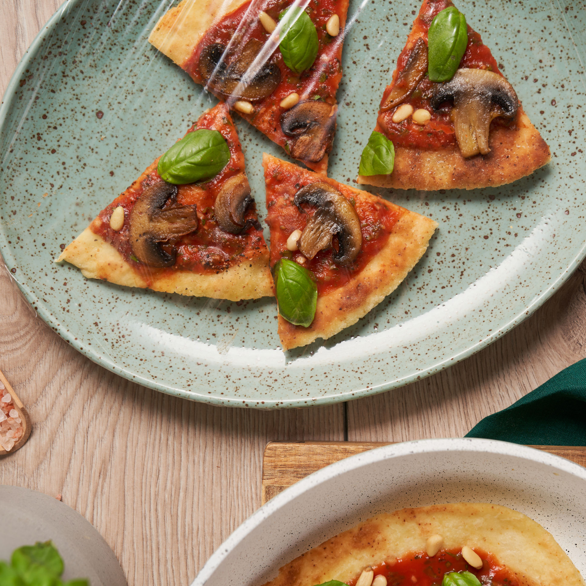 : Pizzastykker på en tallerken dækkes og holdes friske med Toppits® mikrobølgefolie 2-i-1