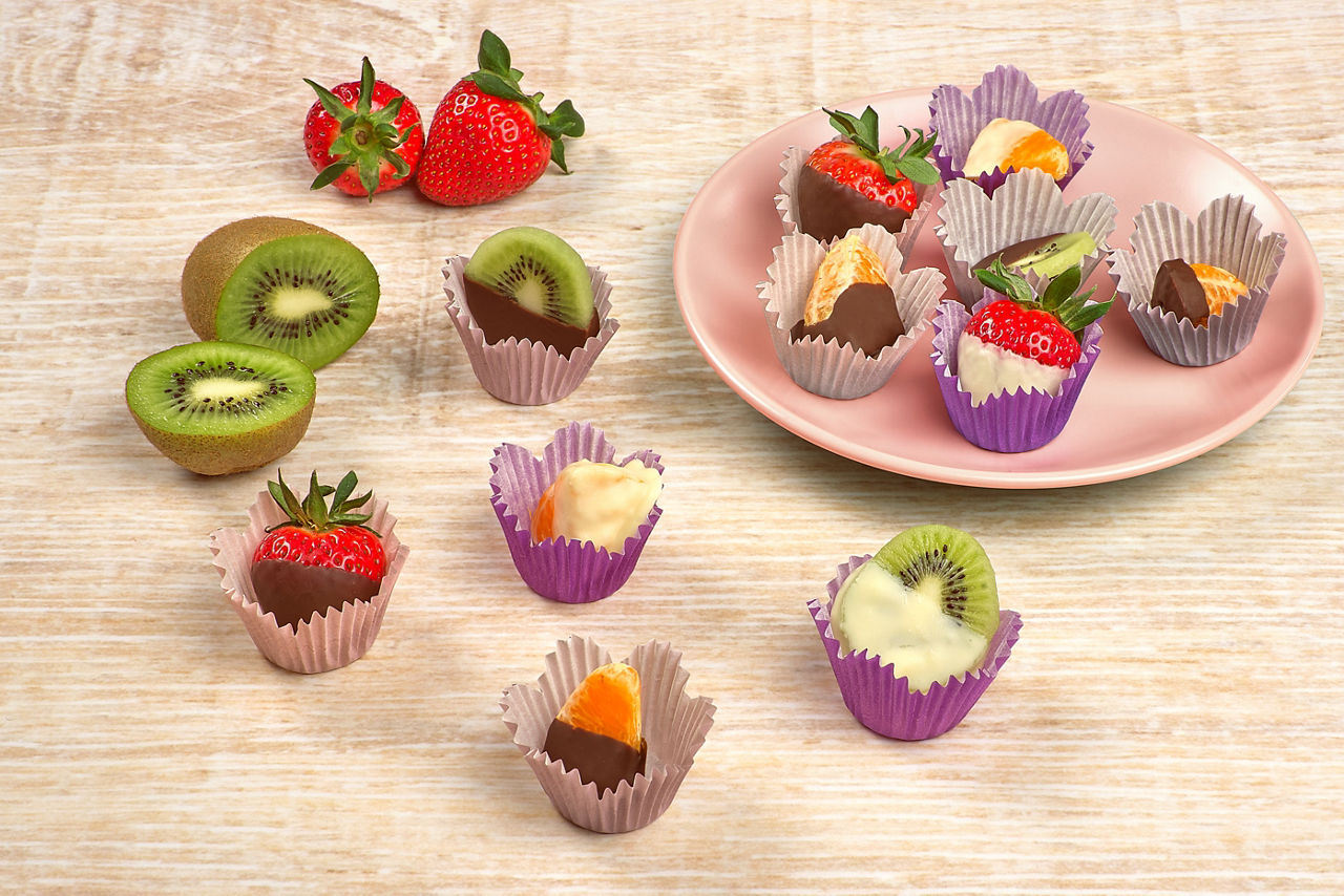 Forskellige Toppits® Muffins papirforme med muffins og frisk frugt på en tallerken