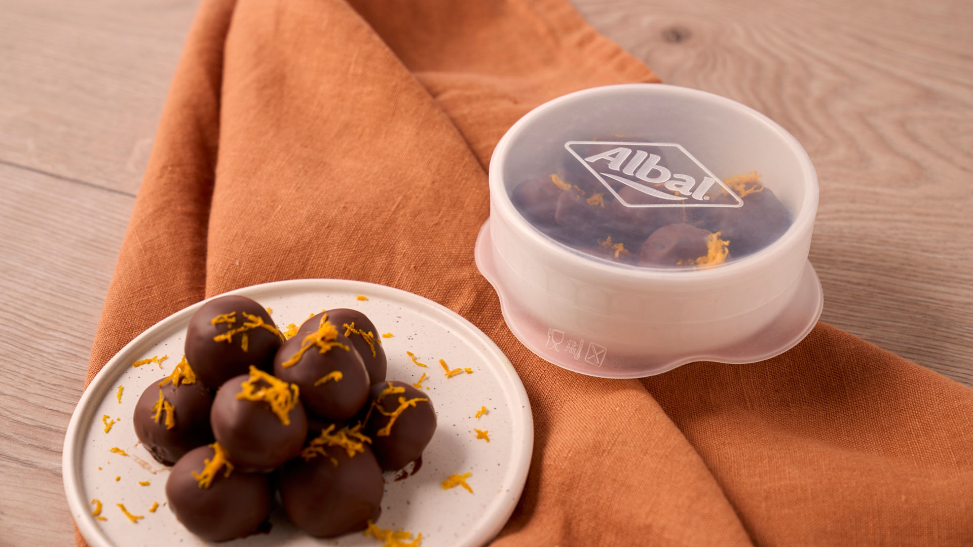 Un bol de tomates et un concombre tranché sont recouverts de couvercles en silicone de® Toppit