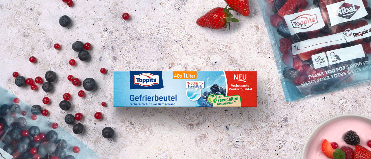 Packung Toppits Gefrierbeutel, umgeben von Beeren und einem gefüllten Gefrierbeutel