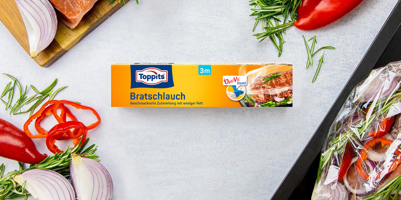 Toppits Bratschlauch 3m mit OptiVit Ventil, umgeben von frischen Zutaten auf  einer gräulichen Küchenarbeitsplatte.