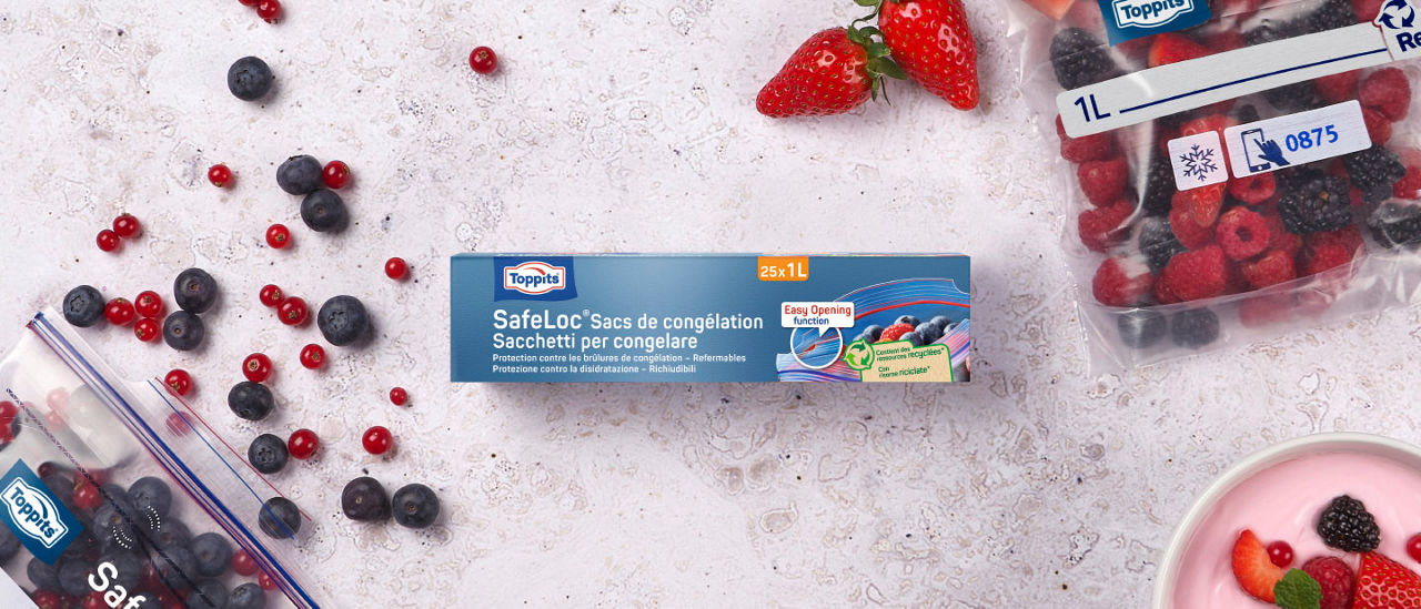 Sacs de congélation Toppits® SafeLoc® 25x1L avec des baies et l’emballage sur fond clair.
