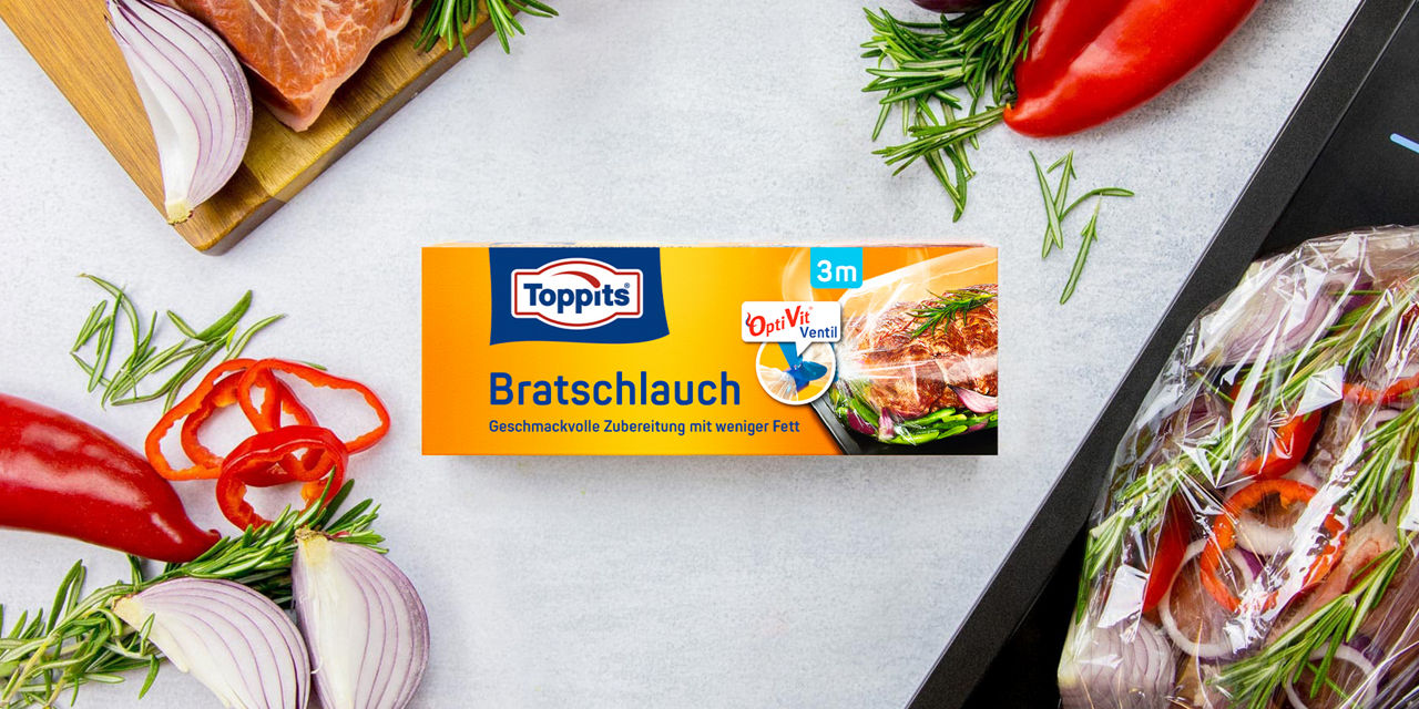 Toppits Bratschlauch 3m mit OptiVit Ventil, umgeben von frischen Zutaten auf Küchenarbeitsplatte.