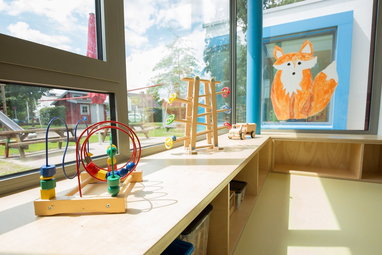 Wooden windowsill with various toys and a marble run.