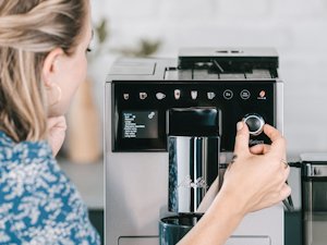 Komfortable Kaffevielfalt_21.png – Melitta® Lifestyle – Woman operates coffee machine within kitchen setting