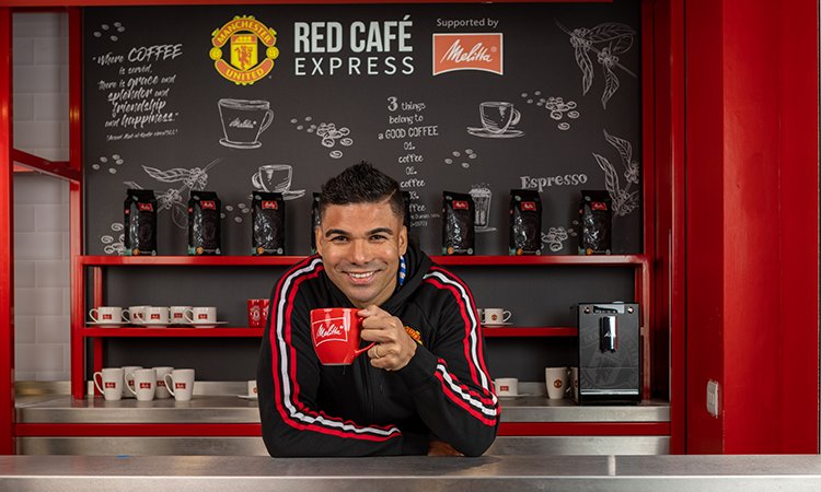 Melitta® ManUnited Casemiro Casemiro leaning over the coffee counter