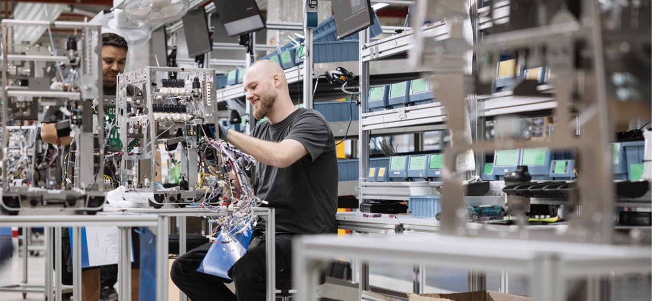 Zwei Kollegen in der Produktion von industriellen Kaffeemaschinen