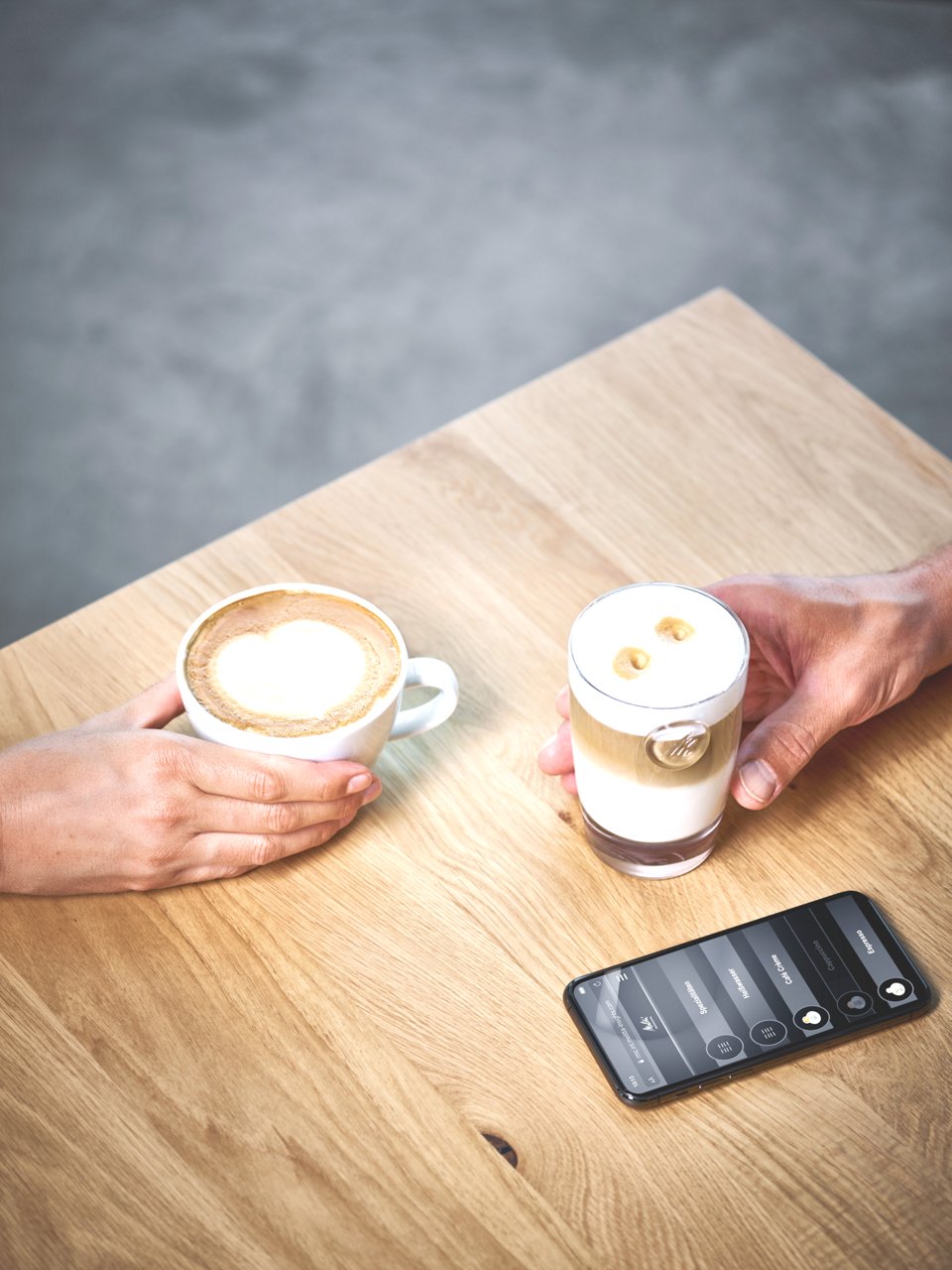 Zwei Kaffeespezialitäten mit Handy auf Tisch