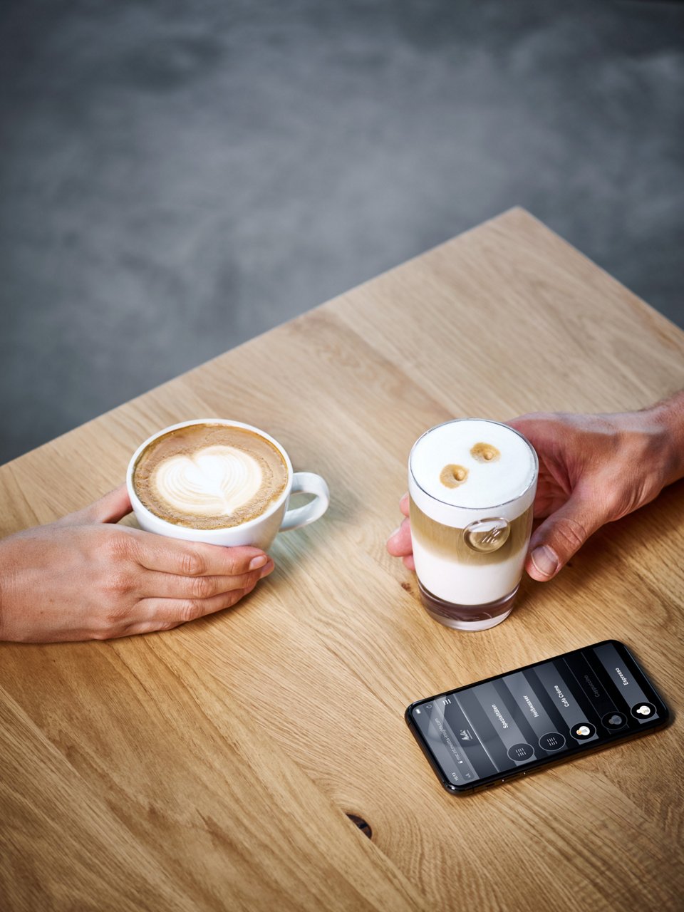 Zwei Kaffeespezialitäten mit Handy auf Tisch