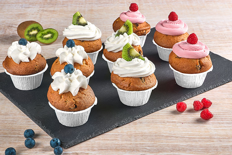 Muffins i stabila vita bakformar från Toppits®, dekorerade med rosa kräm och hallon