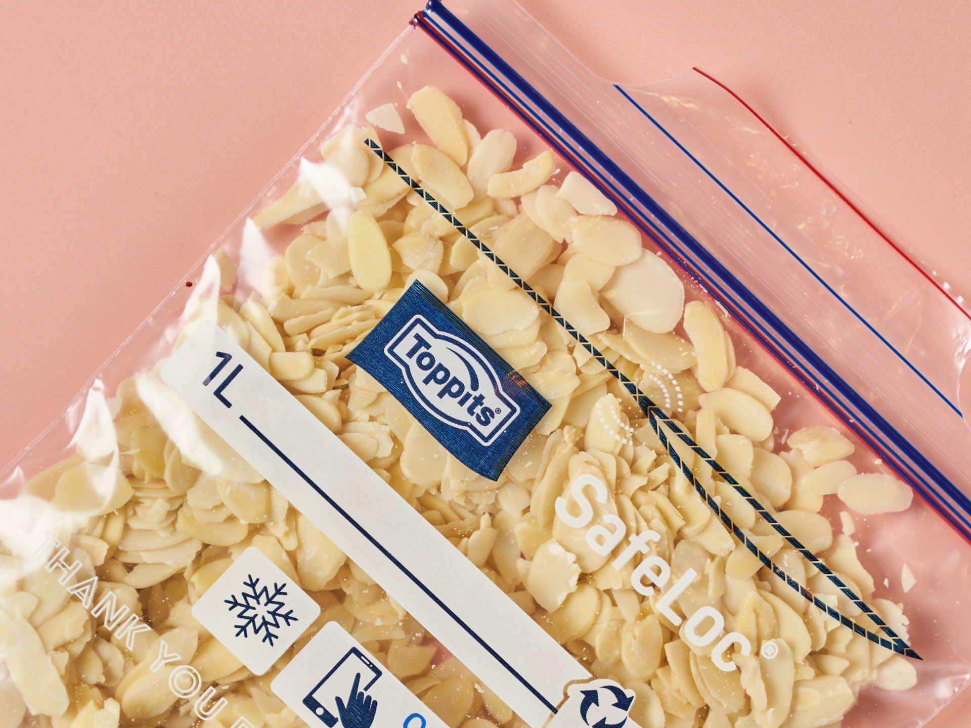 Mandelsplitter in Toppits SafeLoc Beutel bereit zum Einfrieren auf rosa Untergrund.